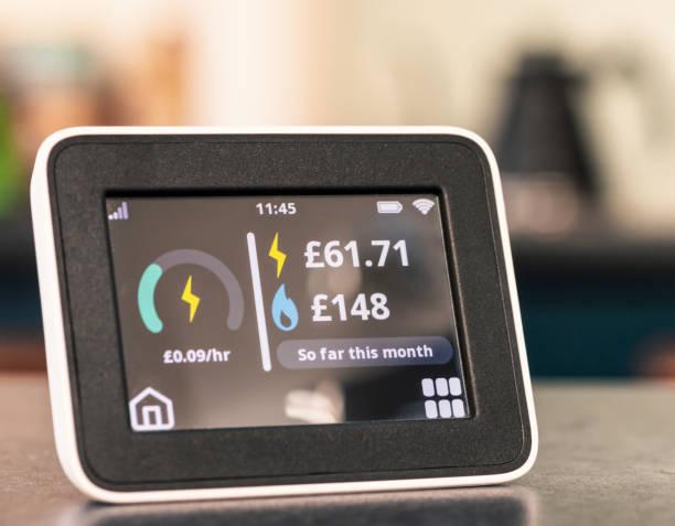 Home energy smartmeter showing expensive monthly figure Close-up of a smart meter in a UK home, showing high electricity and gas expenditure figures for the month. Electronic Components in the Internet of Things (IoT) stock pictures, royalty-free photos & images